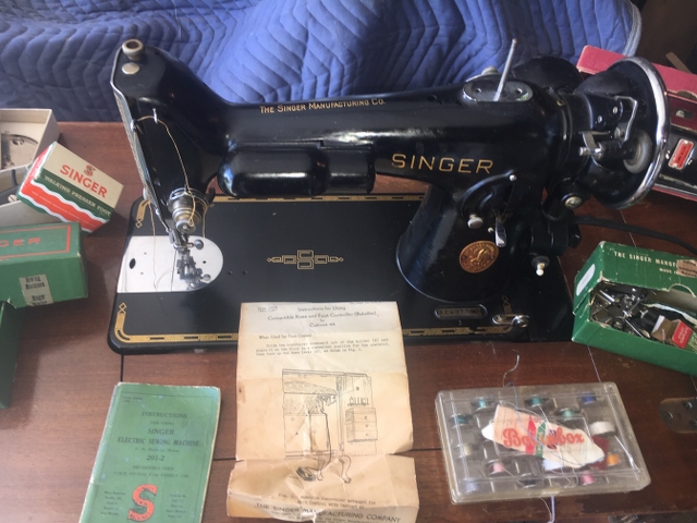 Antique Singer Electric Sewing Machine in original wood cabinet with attachments.